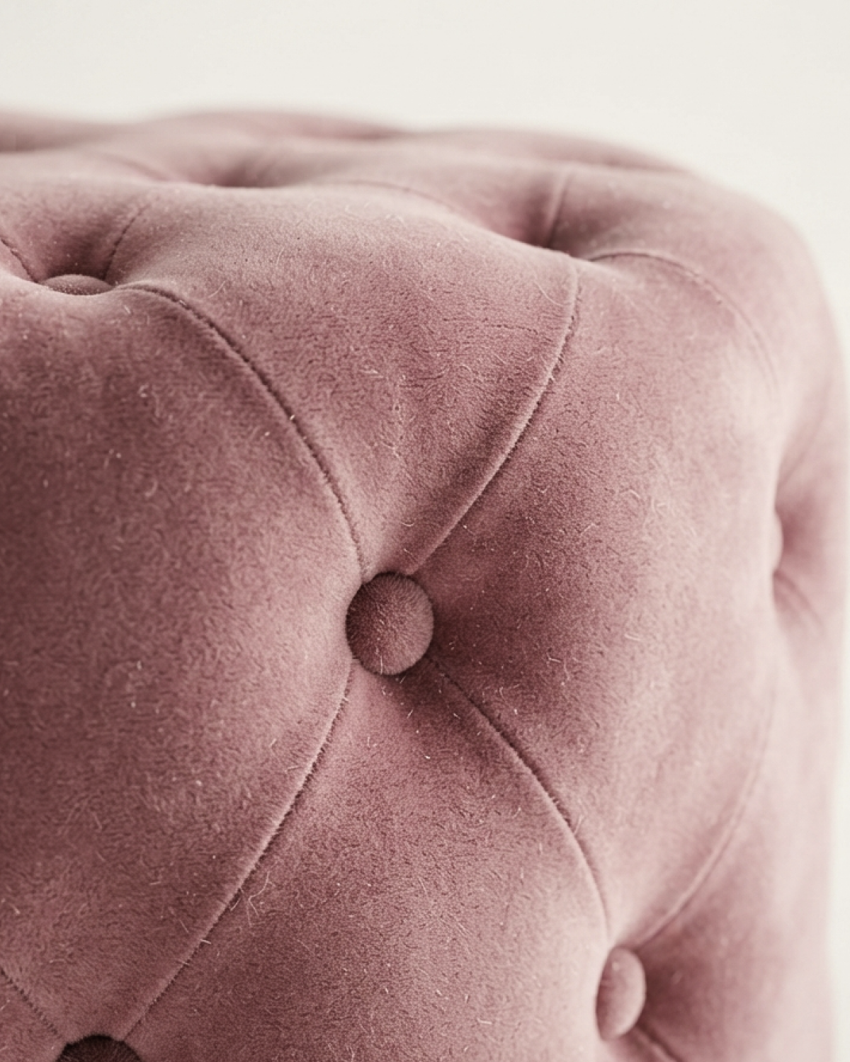 Détail du velours rose et du capitonnage du pouf